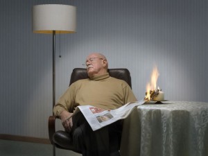 Mann schläft beim Zeitunglesen ein und löst Brand durch Kerze aus.